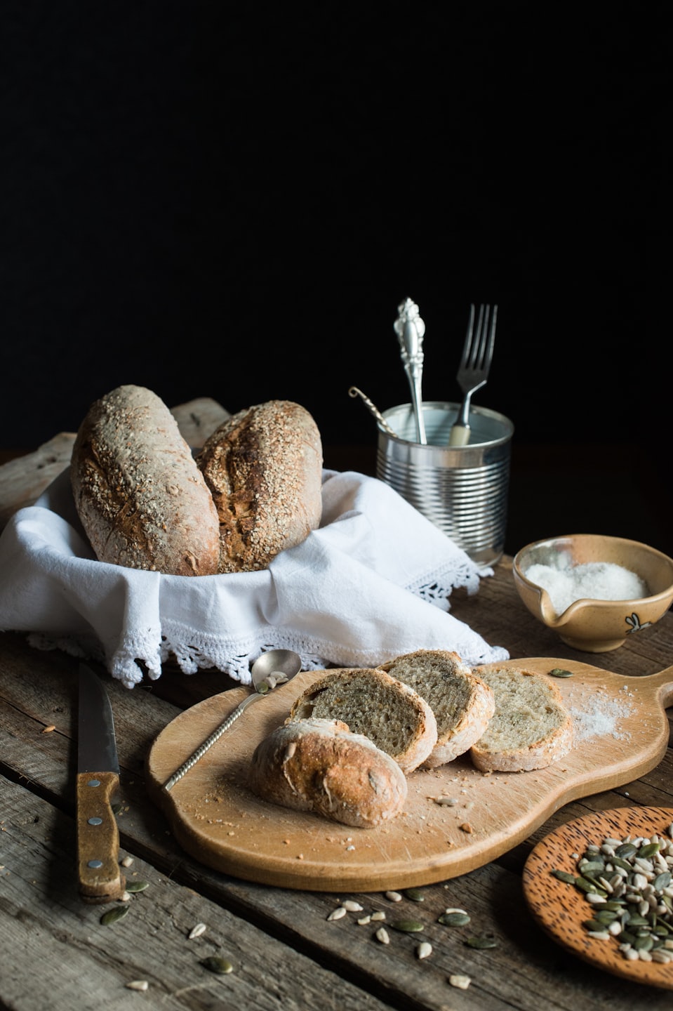 Loaves of fresh bread in a basket and on a cutting board.