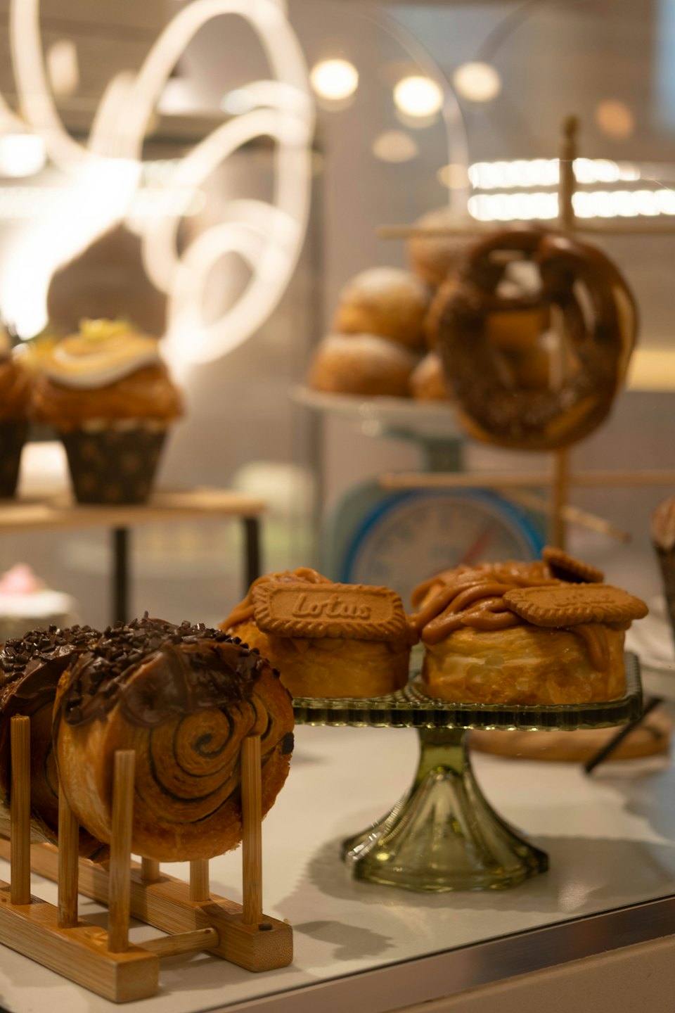 Assorted pastries and cinnamon rolls displayed inside a bakery counter.